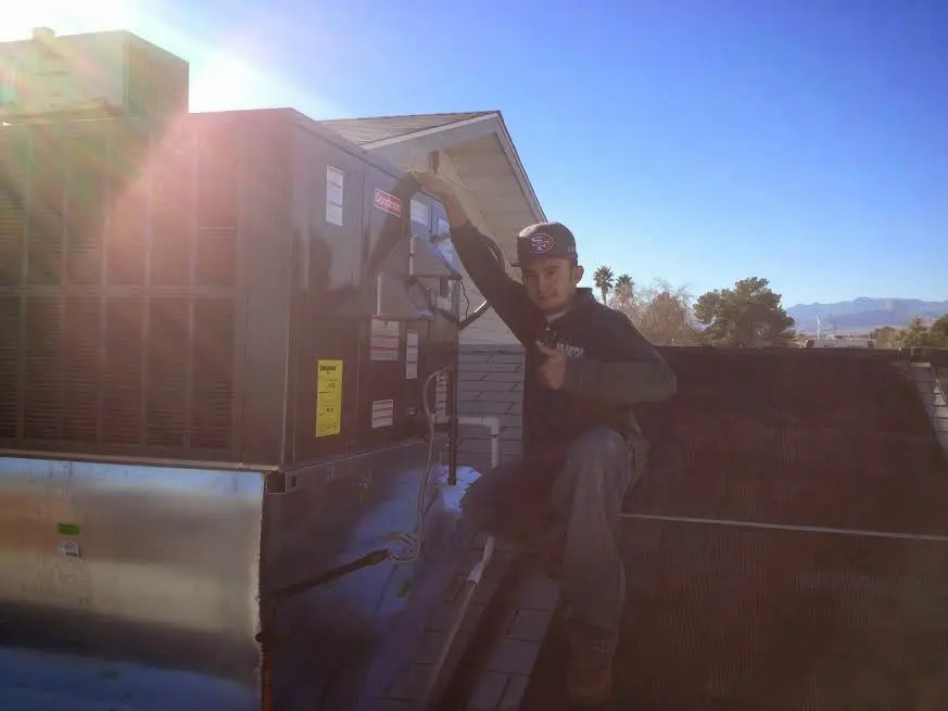 HVAC technician performing AC Tune-Up on a rooftop unit in Eatontown